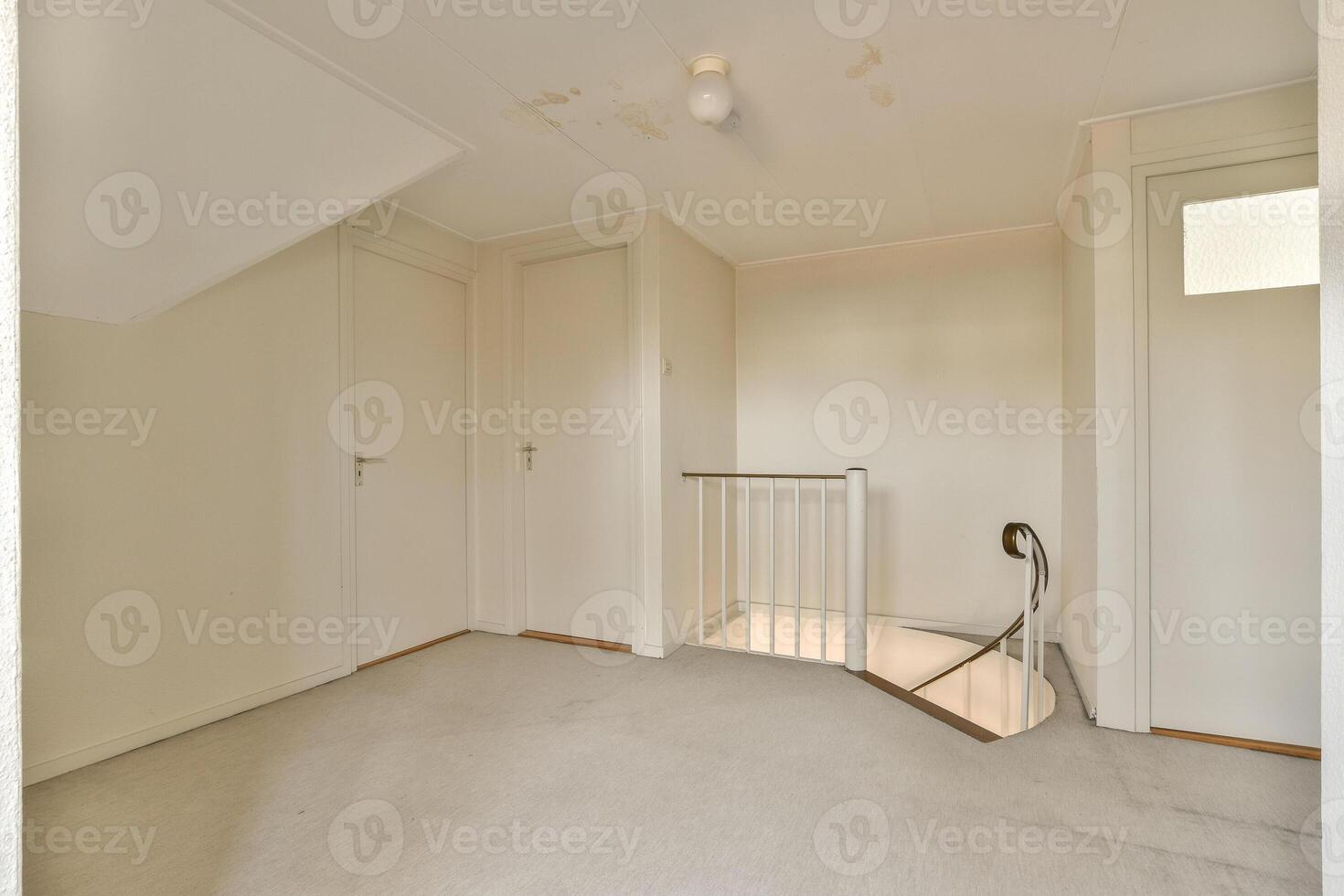 A white room with a stairway and a white door photo
