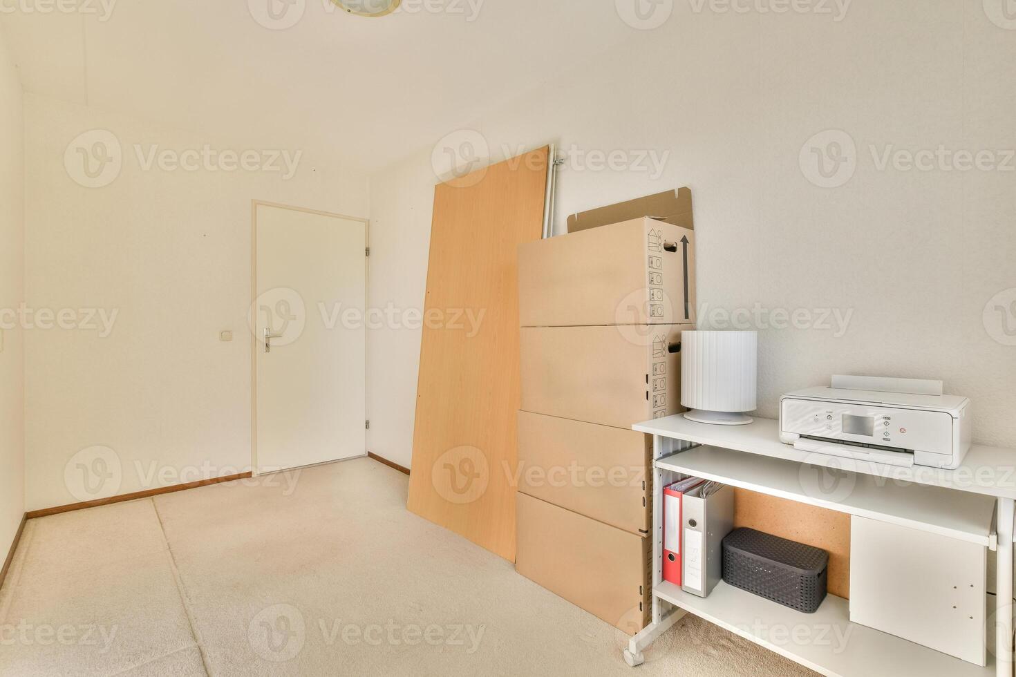 A room with a desk and a printer on the wall photo