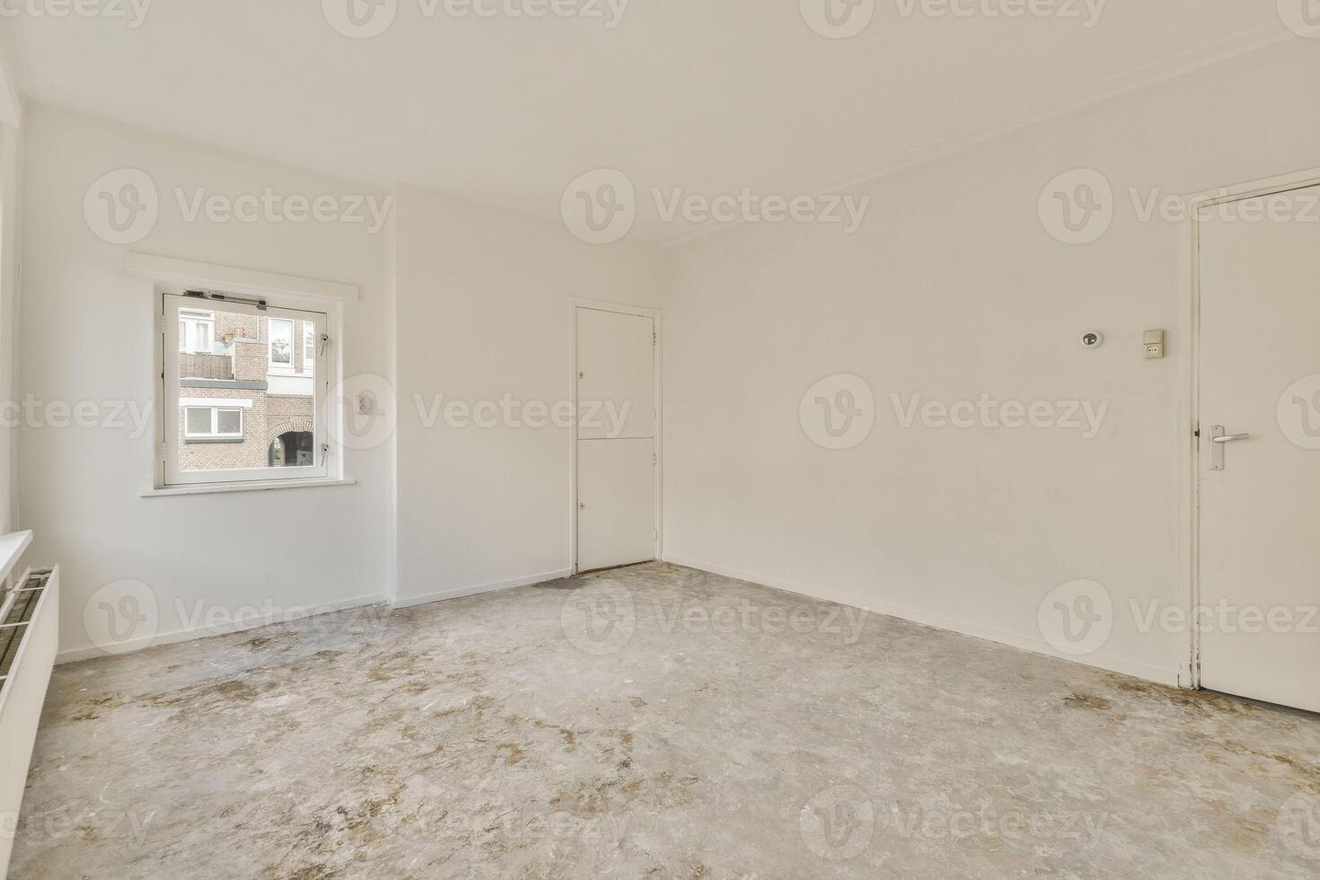 An empty room with a white door and a window photo