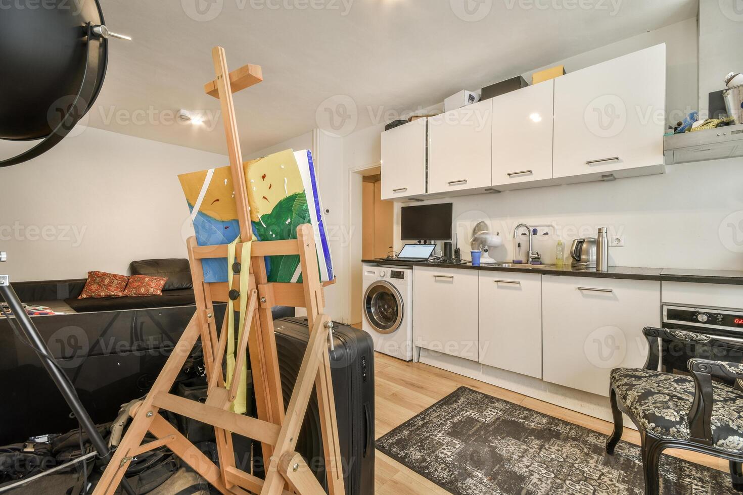 A kitchen with a white refrigerator, a chair and an easel photo