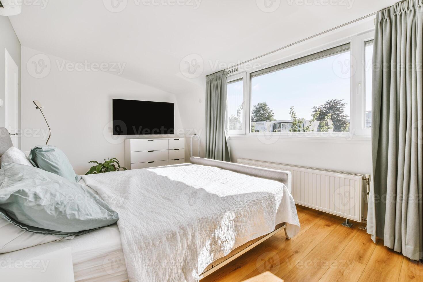 A bedroom with a bed, a television and a window photo