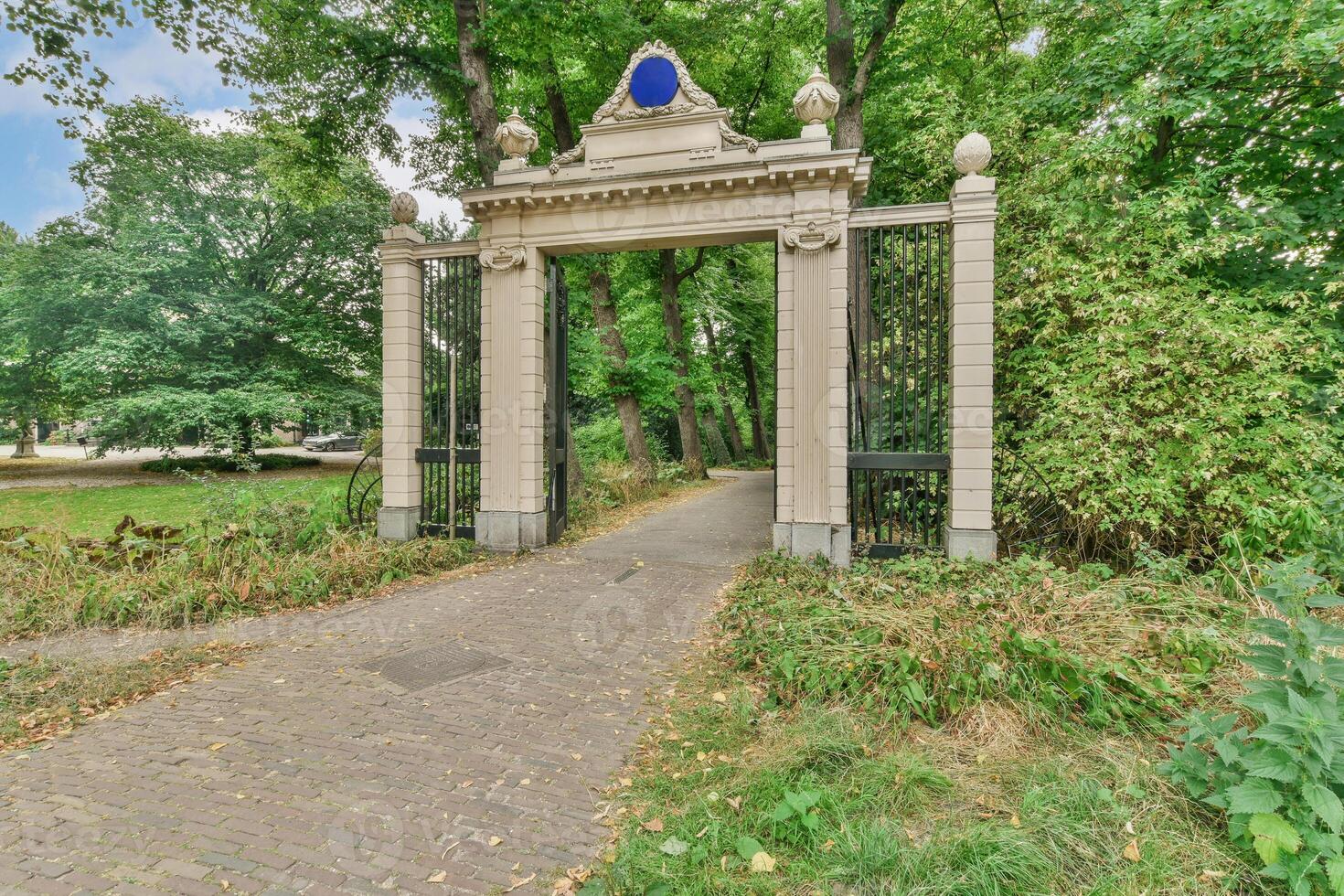 The entrance to a park with a gate and trees photo