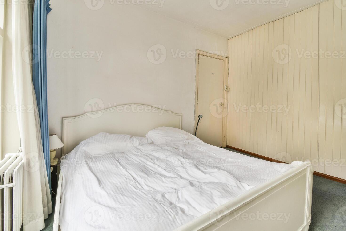 A bed in a bedroom with a window and a radiator photo