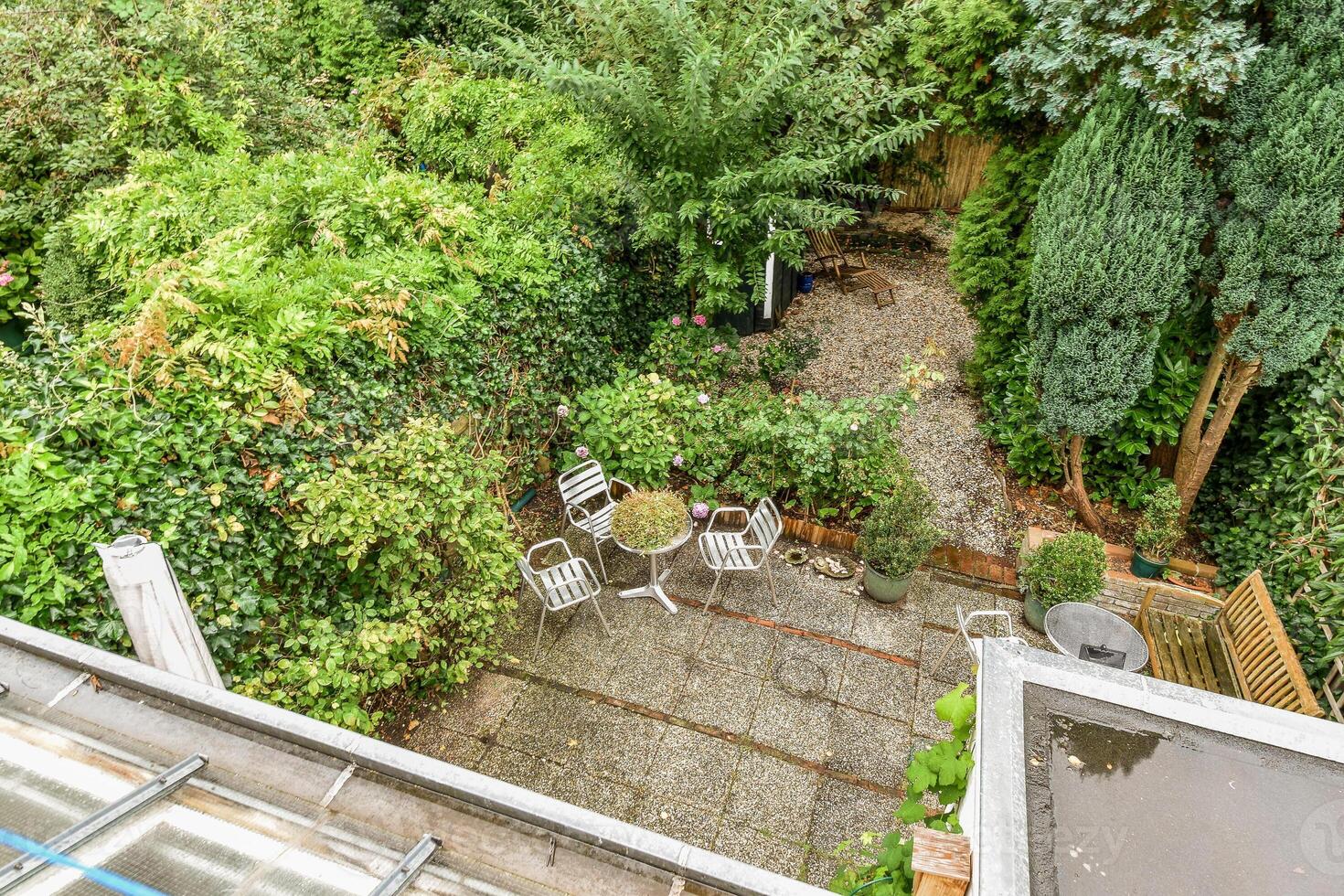 A view of a garden from above with a patio and table photo