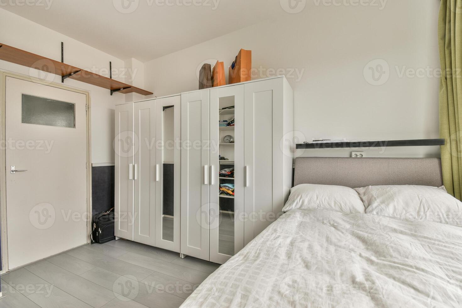 A bedroom with a bed, closet and a wardrobe photo