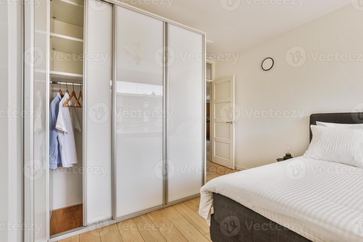 A bedroom with a bed, closet and a closet photo
