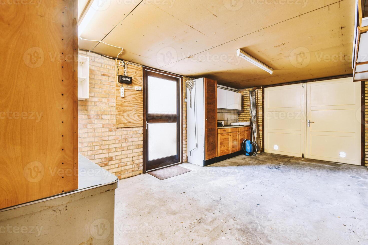 A garage with a refrigerator and a sink photo