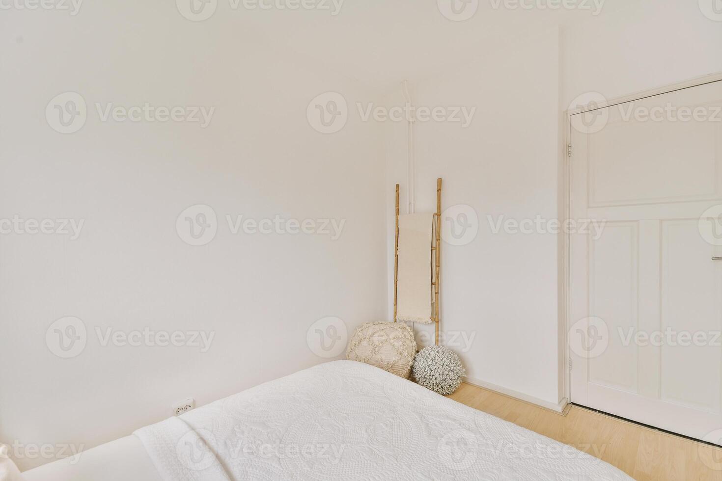 A white bed in a room with a wooden floor photo