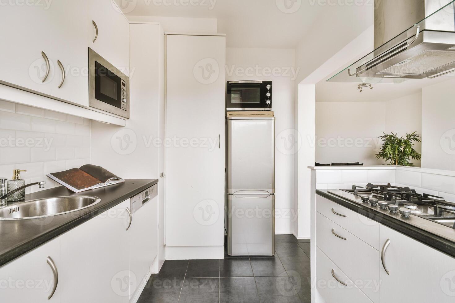 A kitchen with a stove, refrigerator, sink, and microwave photo
