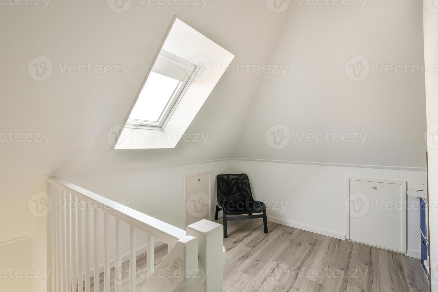 A white stairway with a chair and a window photo