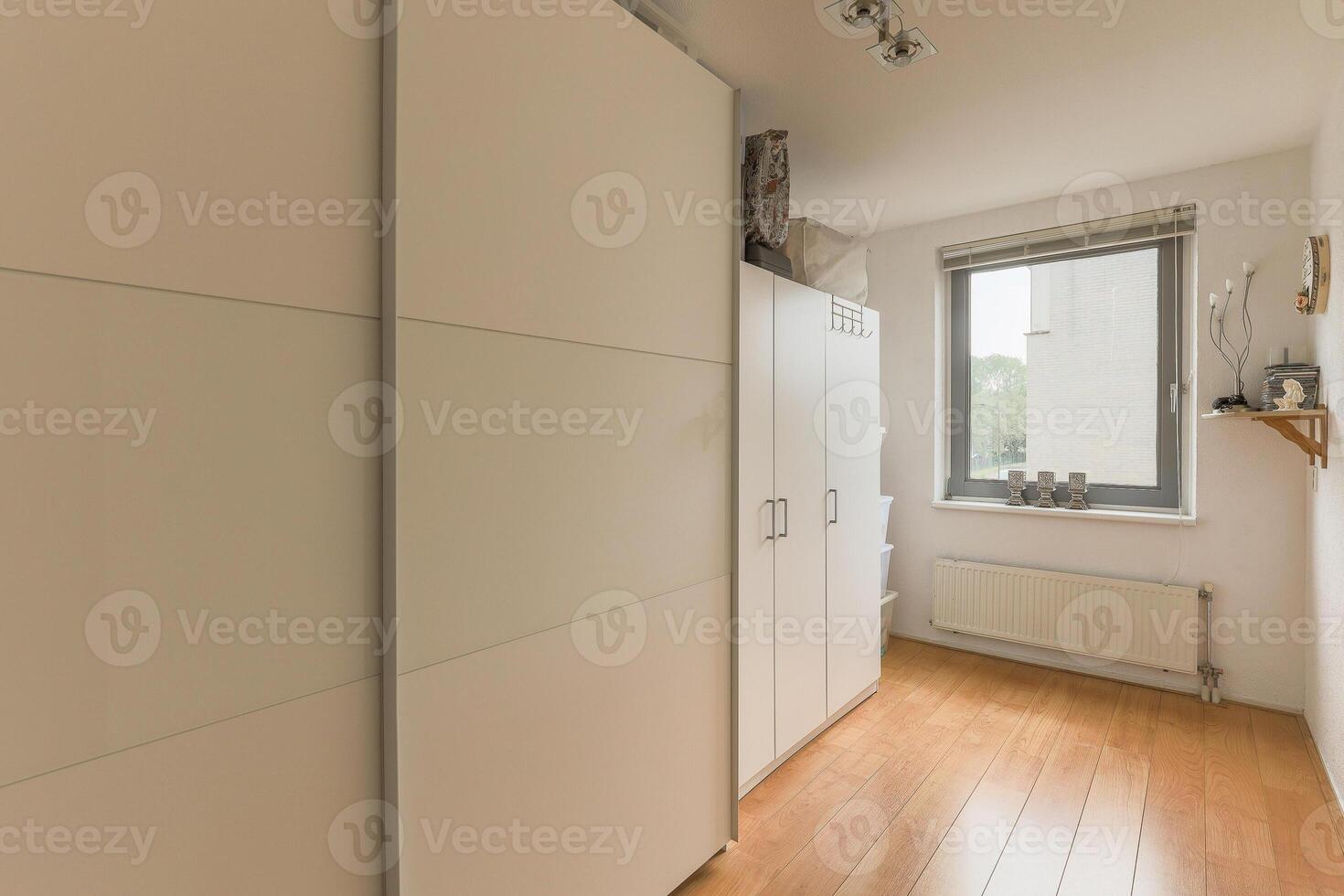 A hallway with white cabinets and wooden floors photo