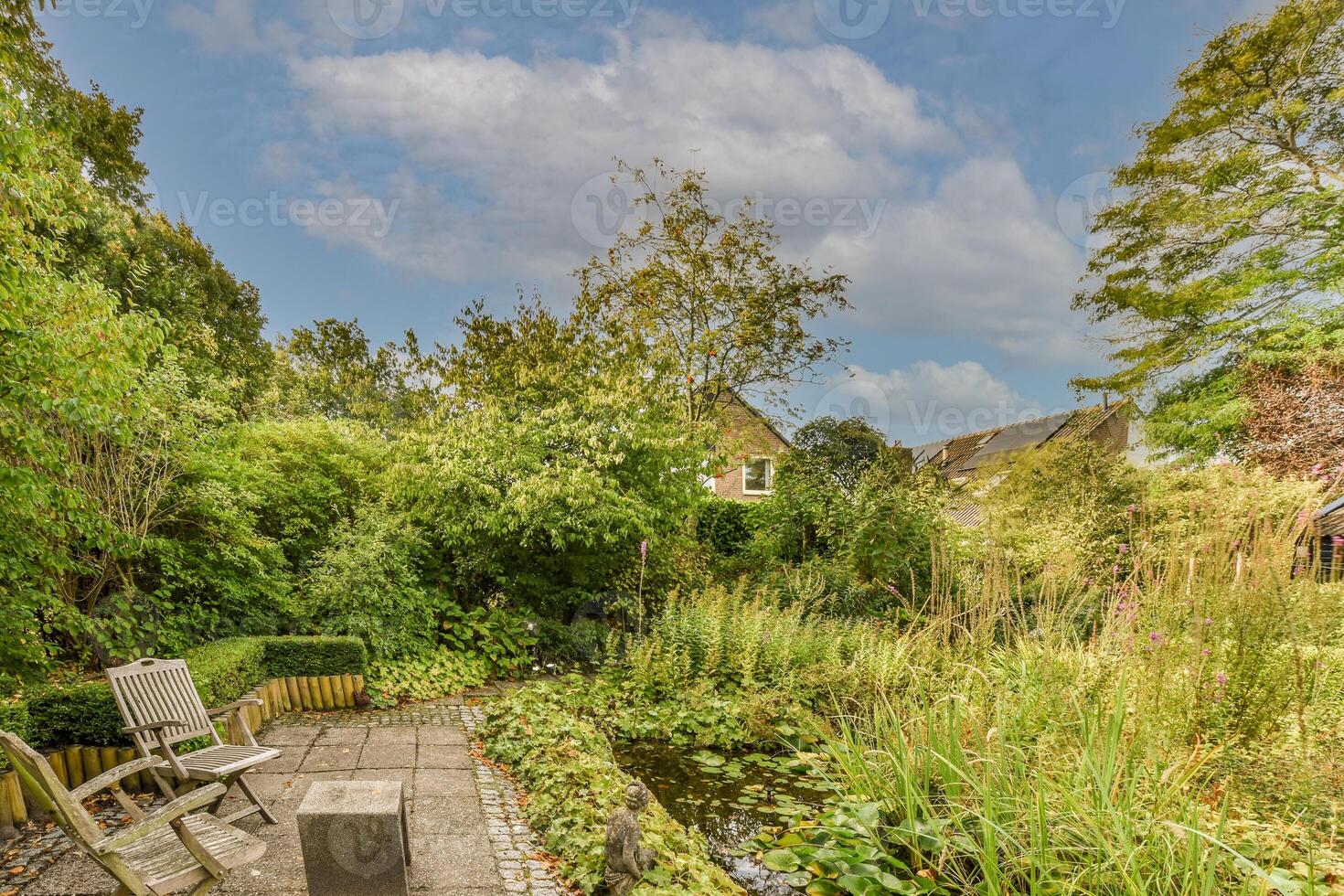 A garden with a bench and a pond in the background photo
