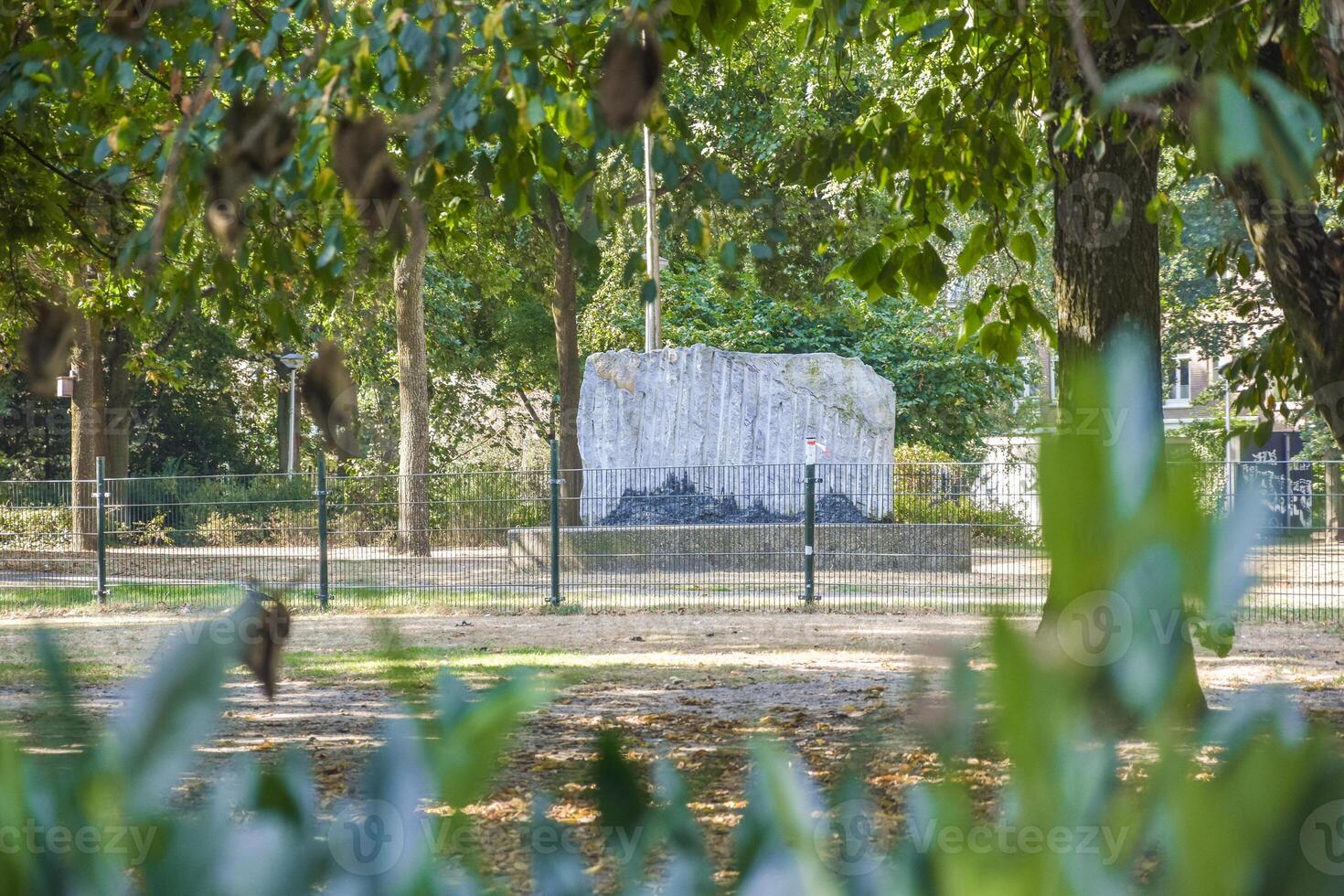 A statue in the middle of a park with trees photo
