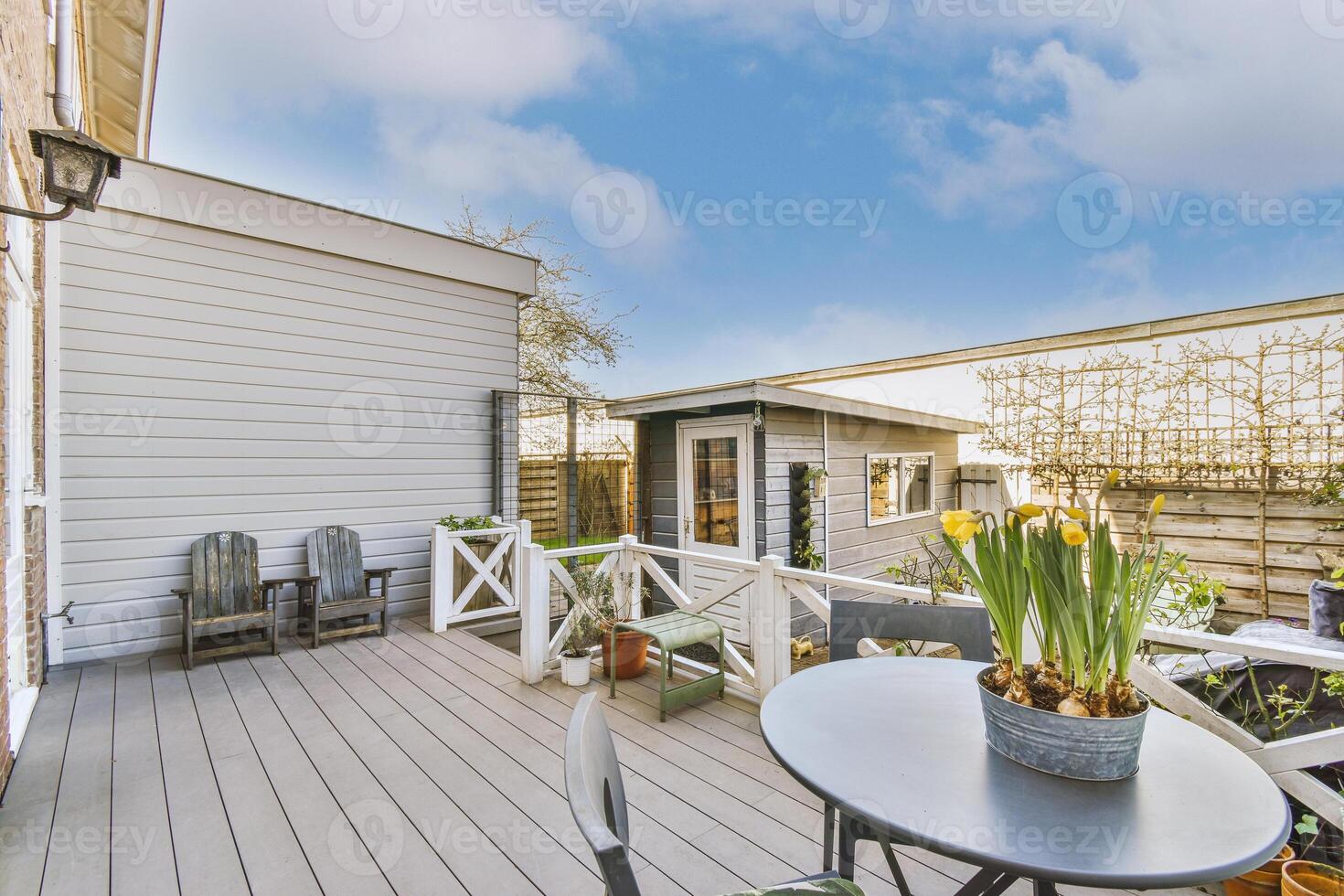 A wooden deck with a table and chairs photo