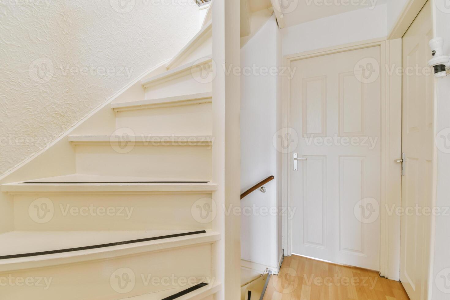 A white stair case with a door and a white door photo