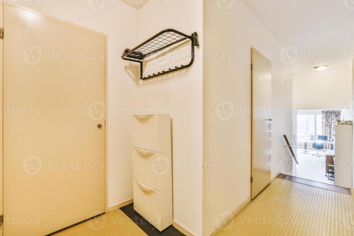 A hallway with a white door and a white cabinet photo
