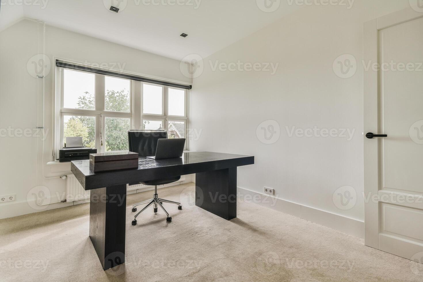 A home office with a desk and chair in front of a window photo