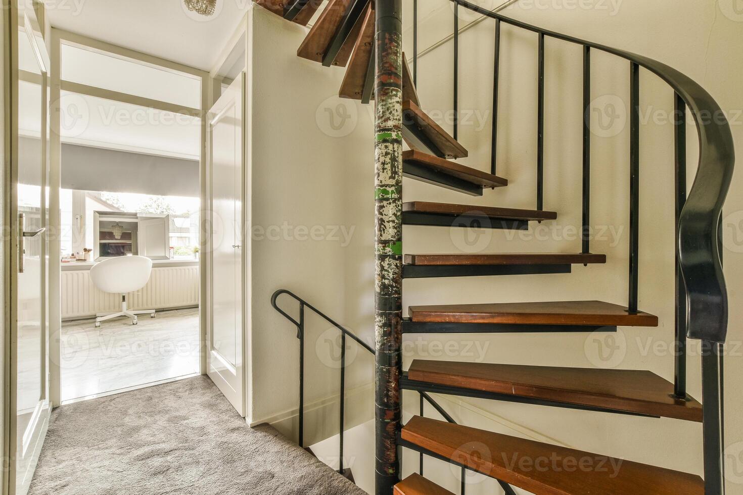 A spiral staircase in a home with a door photo