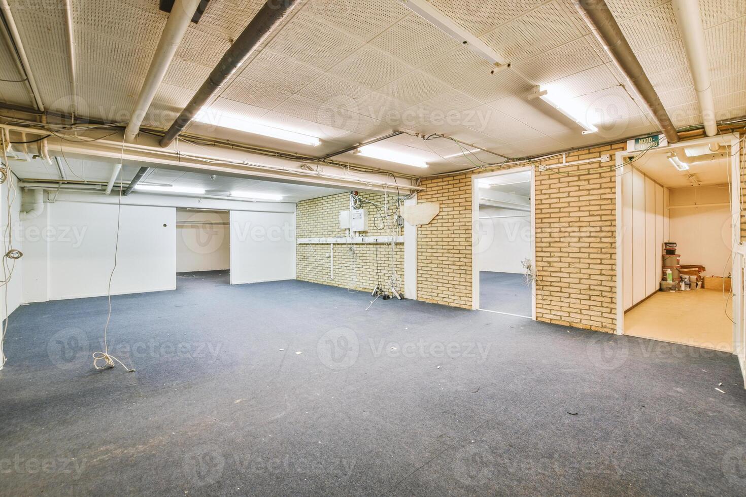 An empty room with a blue carpet and brick walls photo