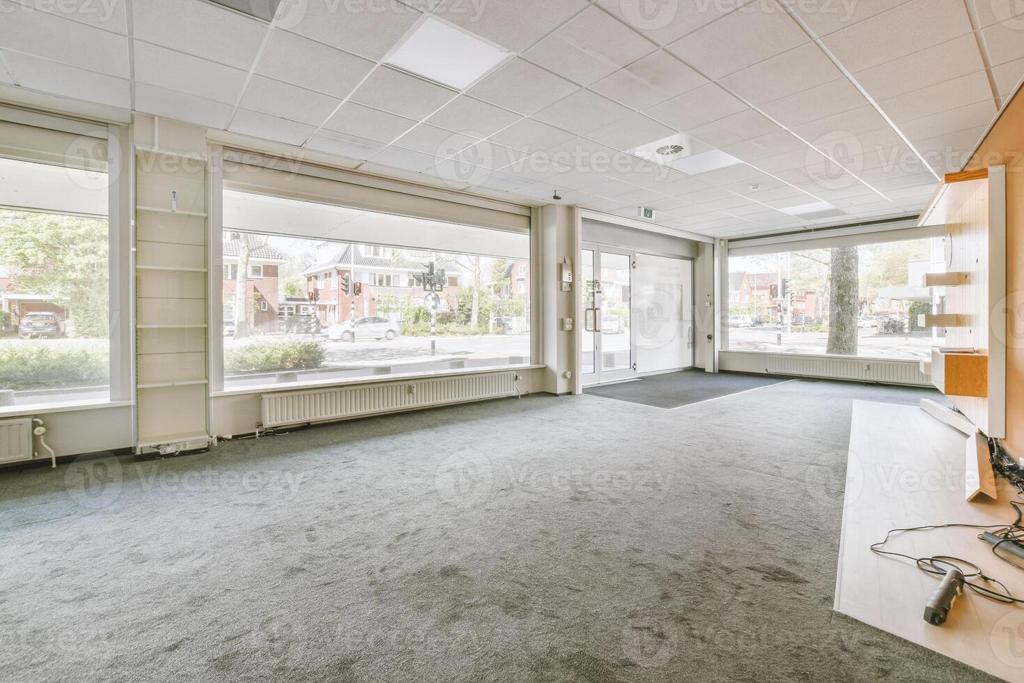 An empty office with a television and a window photo