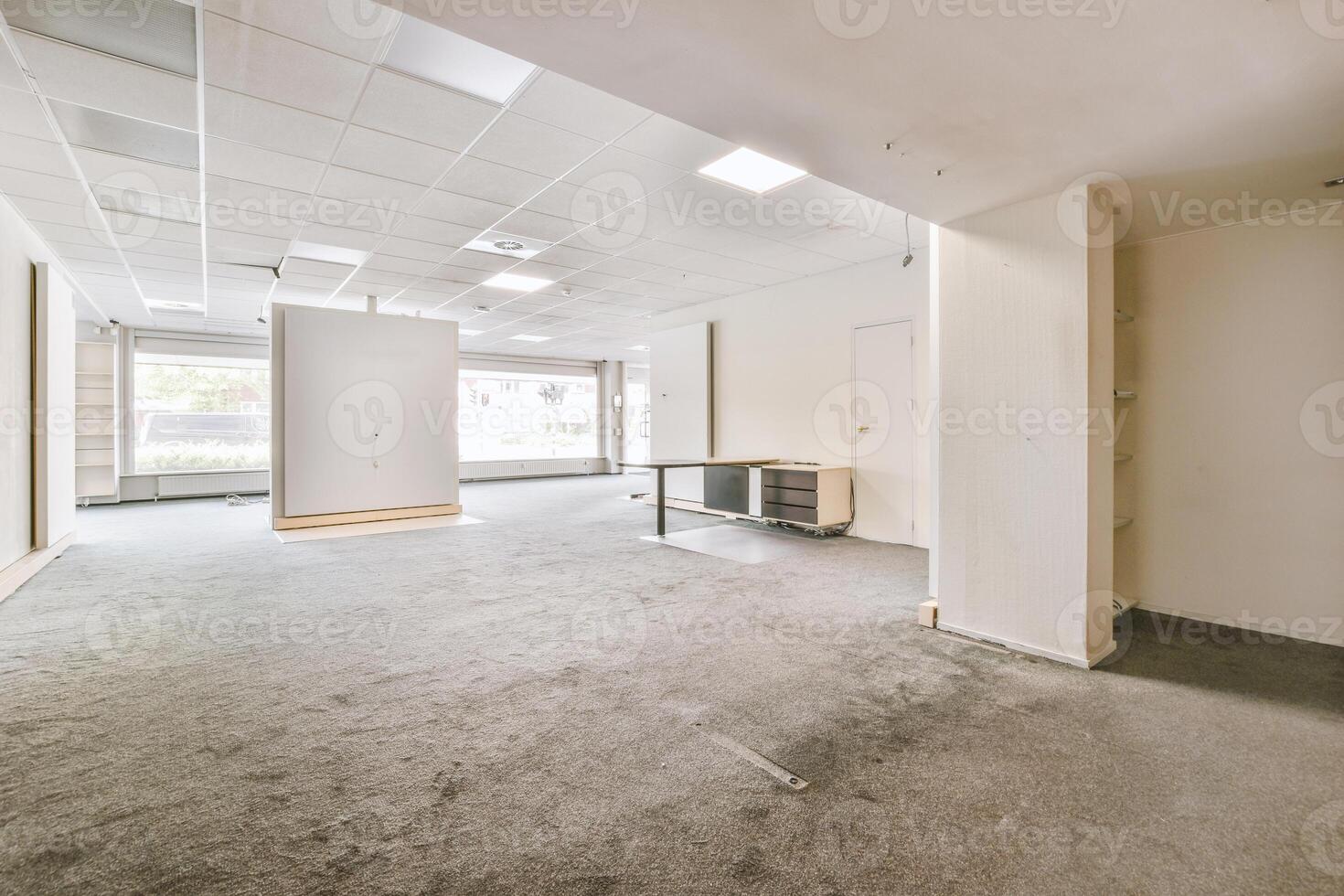 An empty office with a large window and a door photo