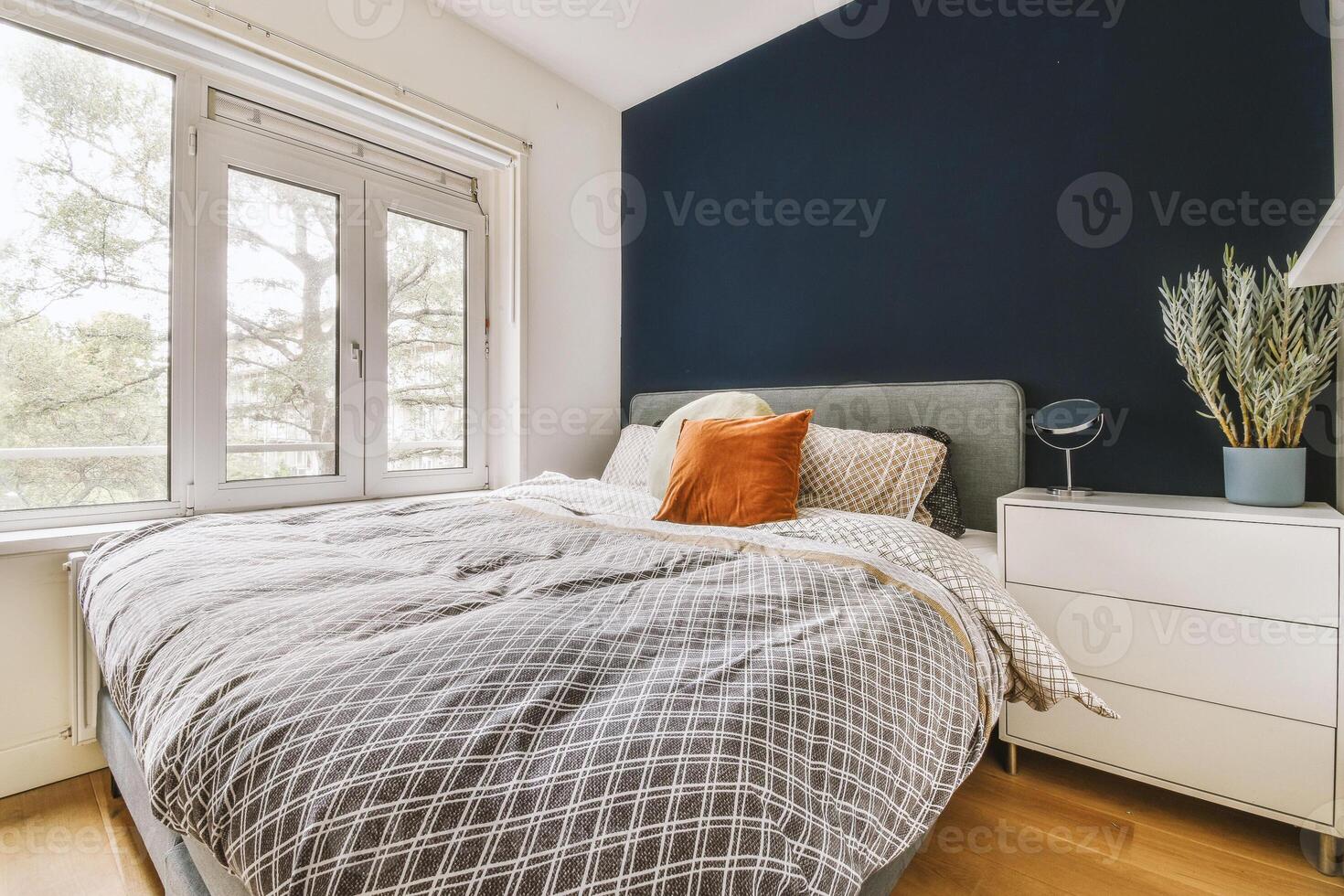 A bedroom with a blue wall and a bed photo