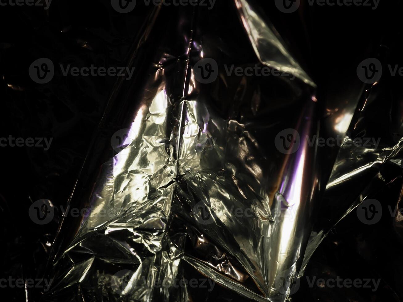 Silver foil in the dark for a mysterious abstract background. photo