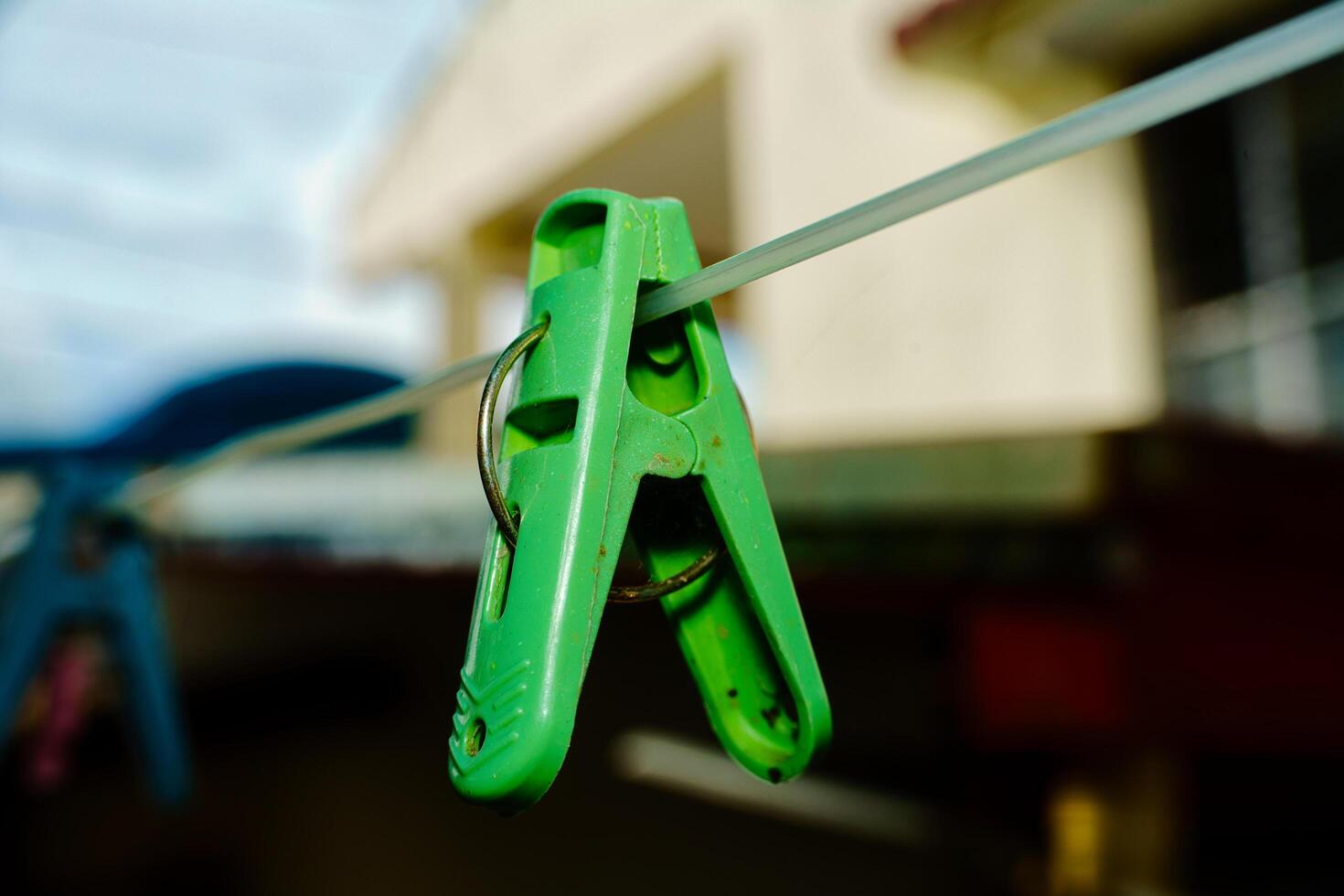 a pair of green plastic clippers hanging on a clothesline photo