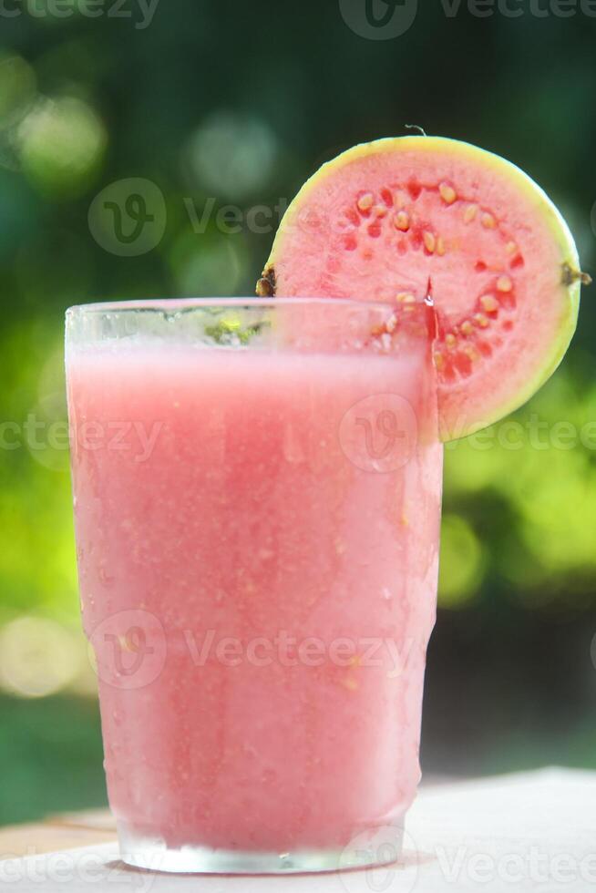 Guava juice, fresh guava juice in glass cup and guava slices on natural background photo