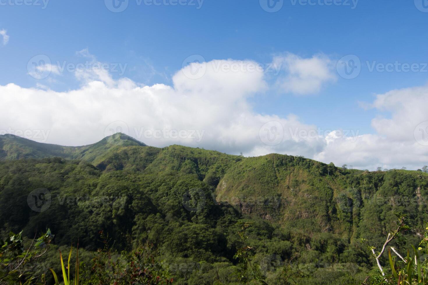 The hill formation of Mount Kelud under a cloudy blue sky, one of the active volcanoes in East Java, Indonesia. photo