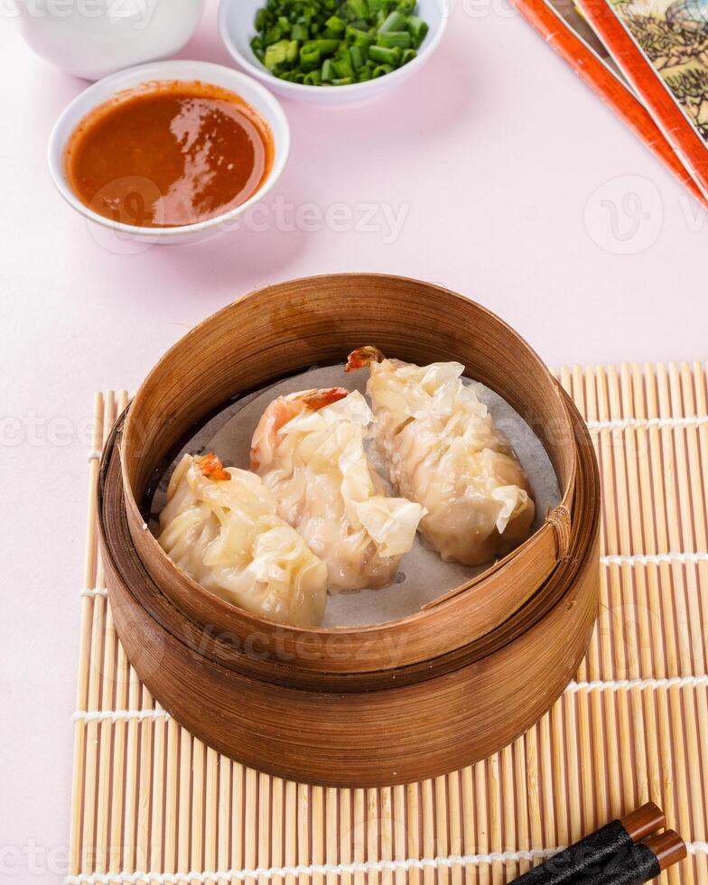 Assorted Chinese Dimsum in bamboo basket. Dimsum is a large range of small dishes that Cantonese people traditionally enjoy in restaurants for breakfast and lunch. photo