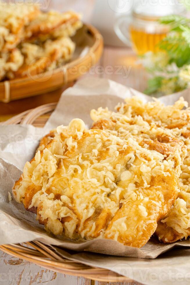 Pisang goreng Coklat Keju is a fritter made by deep frying battered plantain in hot oil. The batter most commonly uses a combination of flour, either wheat, rice flour, tapioca or bread crumb. photo