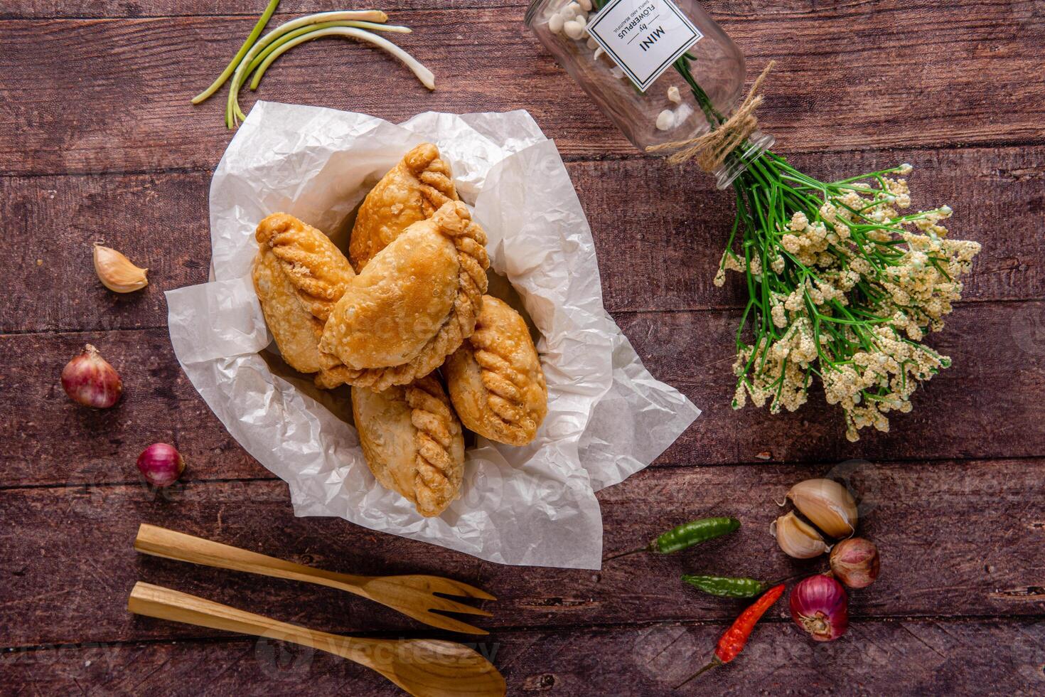 Curry puff or Pastel goreng. it is a small pie consisting of curry with chicken and potatoes in a deep fried or baked pastry shell photo
