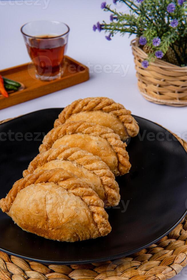 Curry puff or Pastel goreng. it is a small pie consisting of curry with chicken and potatoes in a deep fried or baked pastry shell photo