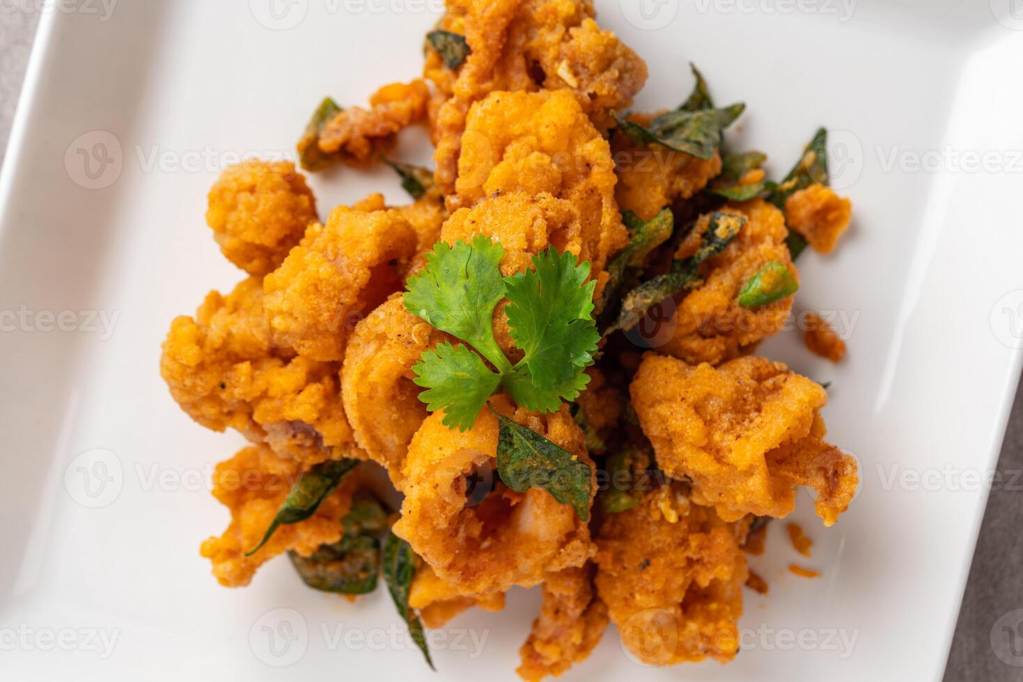Stir Fried Squid with Salted Egg Yolk plating on white plate. photo