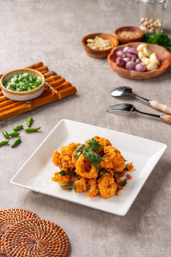 Stir Fried Squid with Salted Egg Yolk plating on white plate. photo