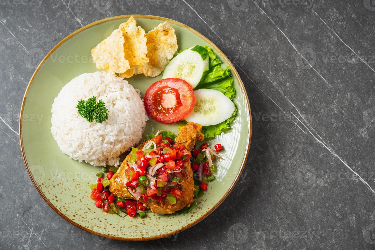 Nasi Ayam Geprek is Indonesian Food crispy fried chicken with hot and spicy sambal bawang. Served with rice photo