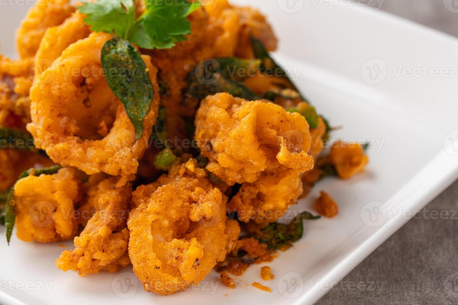 Stir Fried Squid with Salted Egg Yolk plating on white plate. photo
