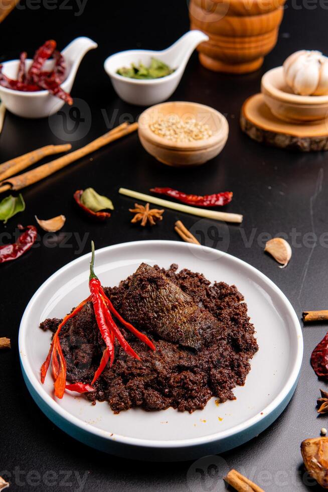 Beef Rendang is a Minang dish originating from the Minangkabau region in West Sumatra, Indonesia. Rendang has been slow cooked and braised in a coconut milk seasoned with a herb and spice mixture photo