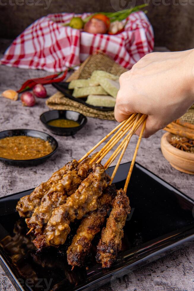 Pork Satay or Sate Babi. Pork Satay served with a Peanut sauce and slices of lontong or ketupat photo