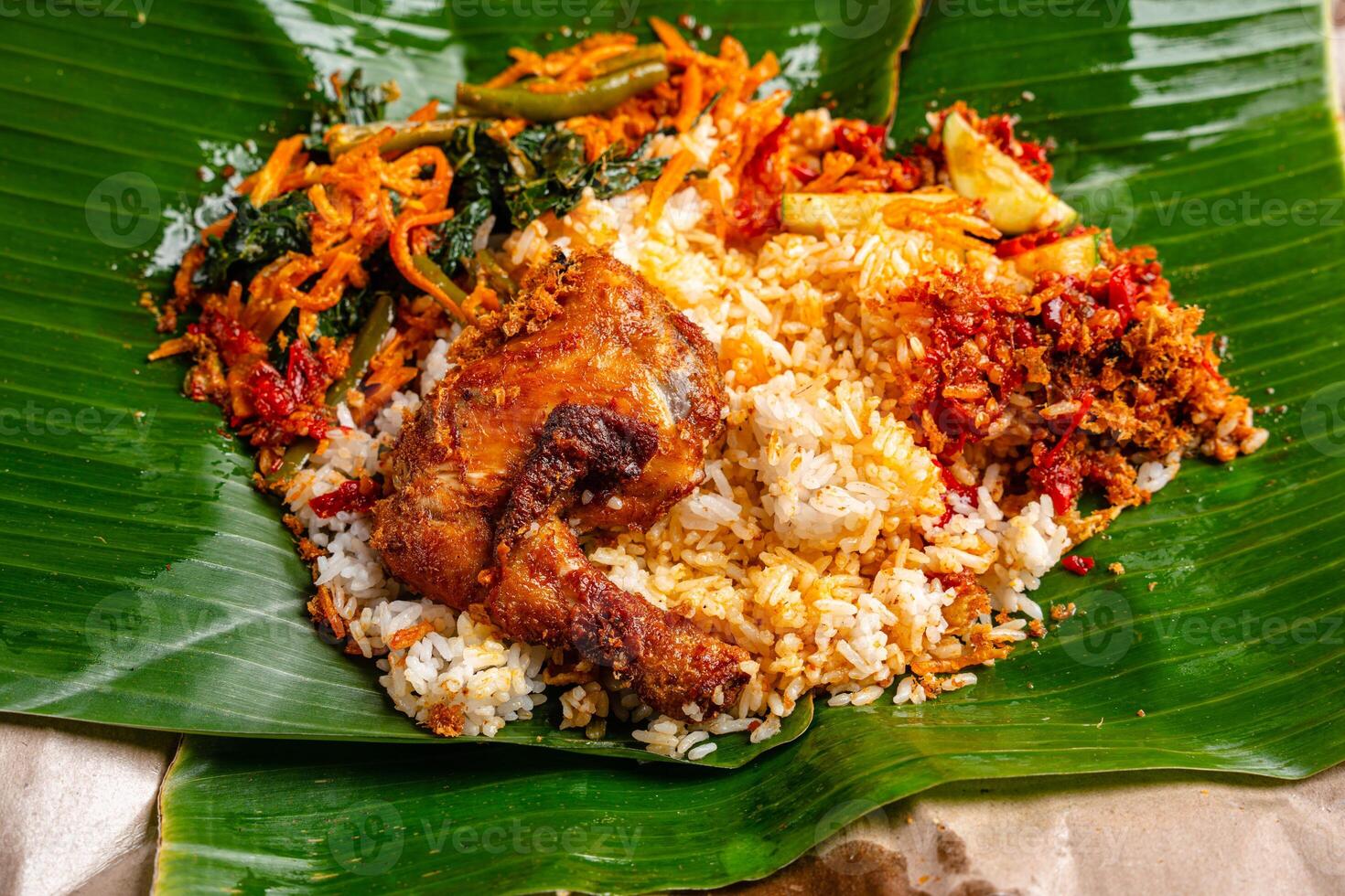 Indonesian padang food or nasi bungkus with padang fried chicken or Ayam goreng padang photo