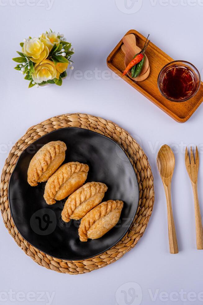 Curry puff or Pastel goreng. it is a small pie consisting of curry with chicken and potatoes in a deep fried or baked pastry shell photo