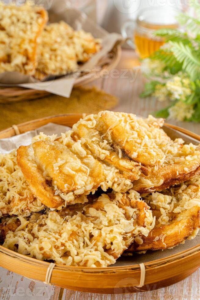 Pisang goreng Coklat Keju is a fritter made by deep frying battered plantain in hot oil. The batter most commonly uses a combination of flour, either wheat, rice flour, tapioca or bread crumb. photo