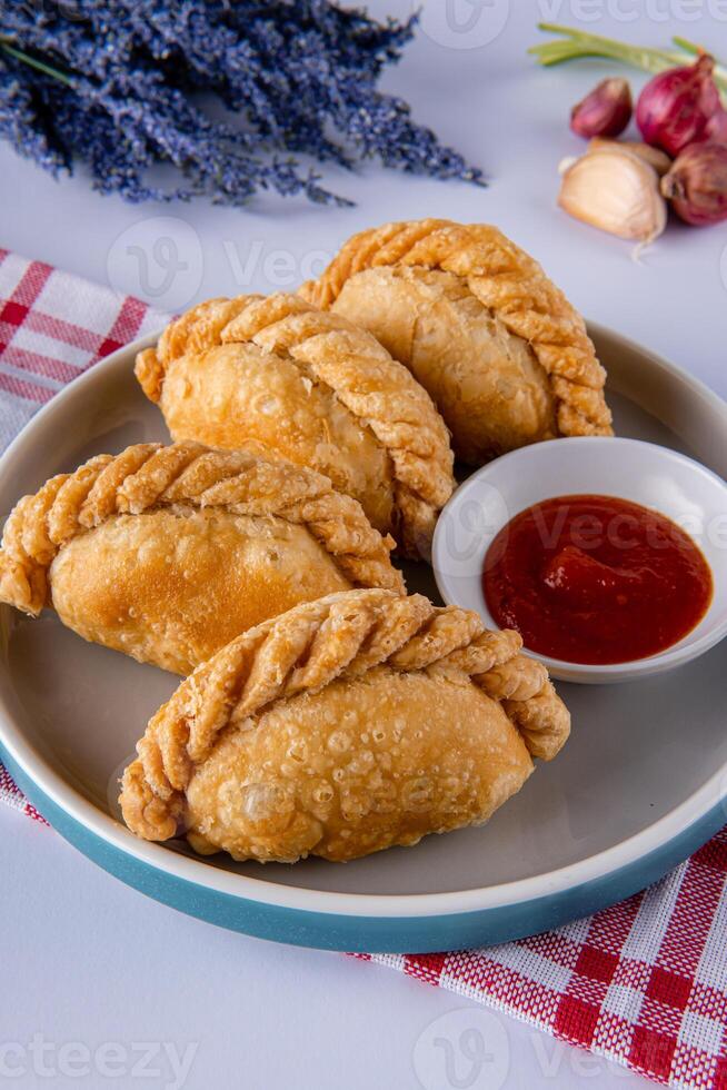 Curry puff or Pastel goreng. it is a small pie consisting of curry with chicken and potatoes in a deep fried or baked pastry shell photo
