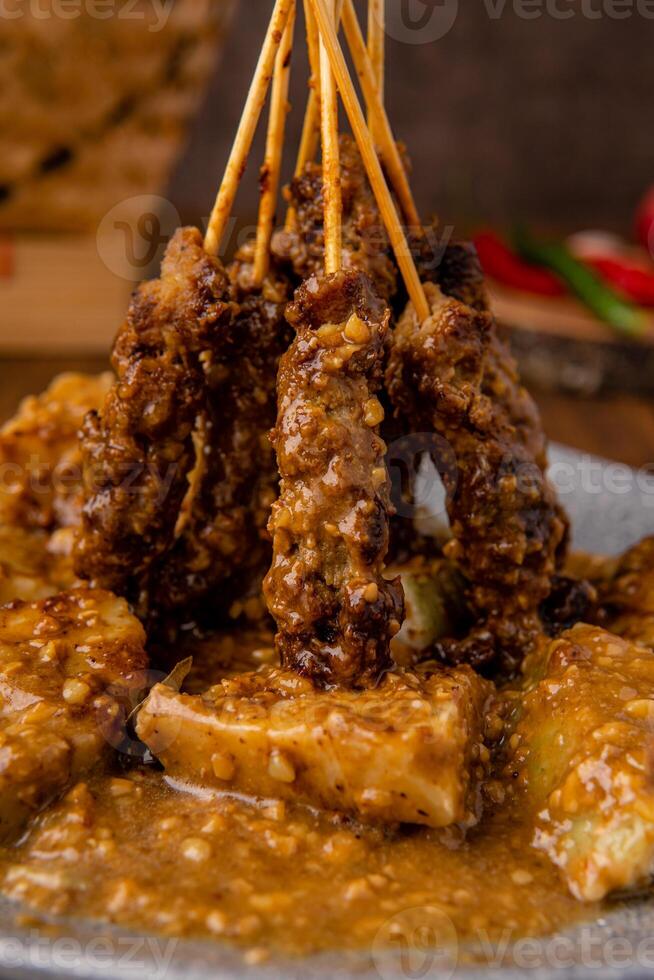 Pork Satay or Sate Babi. Pork Satay served with a Peanut sauce and slices of lontong or ketupat photo
