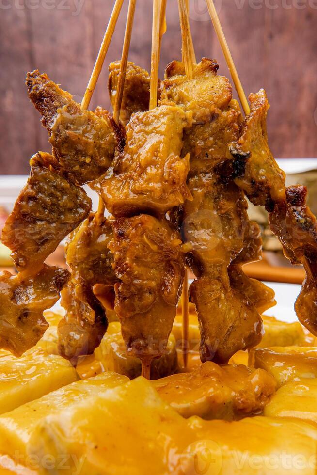 Pork Satay served with a spicy Padang sauce and slices of lontong or rice cakes garnished with a sprinkle of crisp fried shallot photo