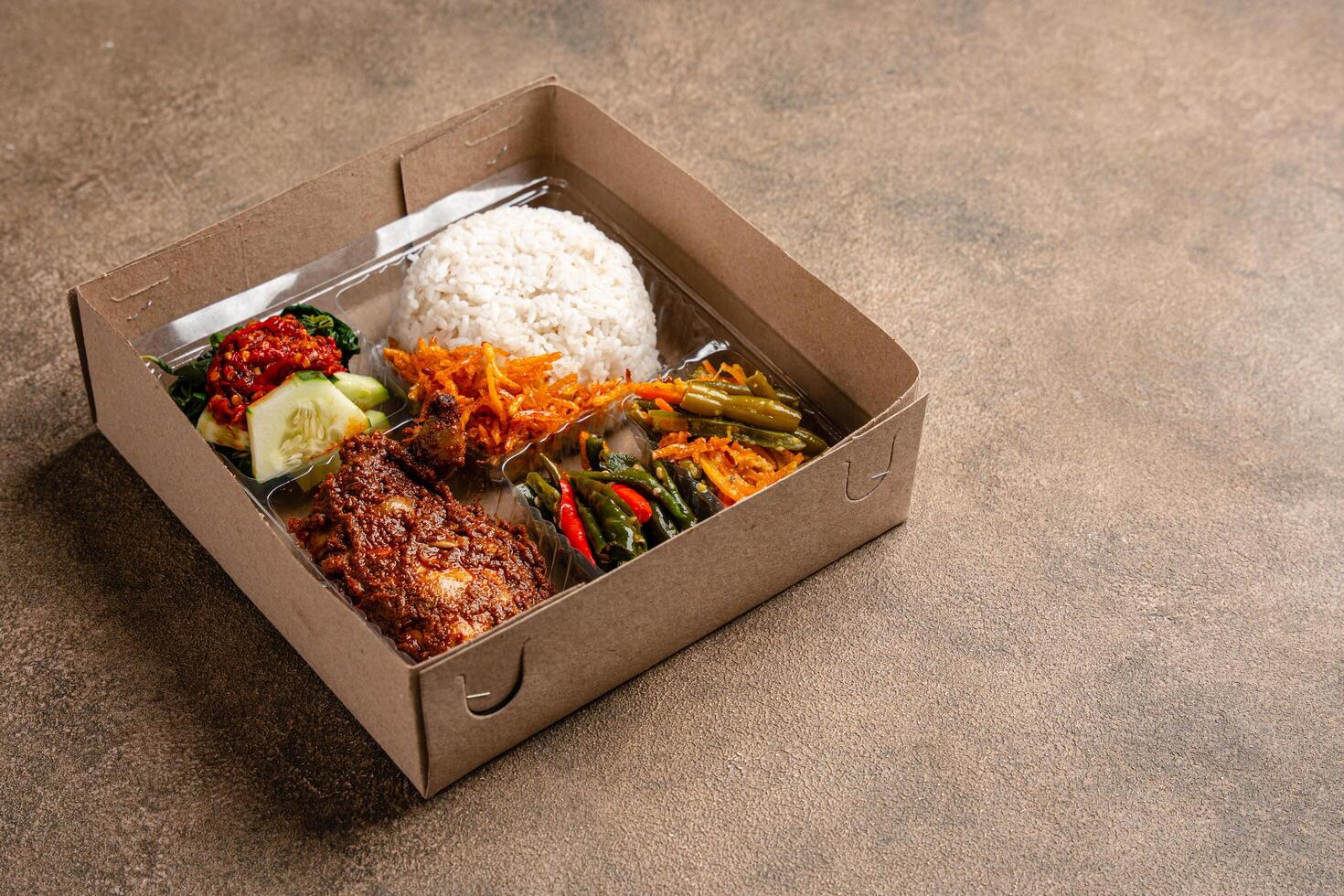 In Indonesian it is called Rice Box or Nasi kotak with ayam rendang. Usually distributed during celebrations or catering packaging. photo