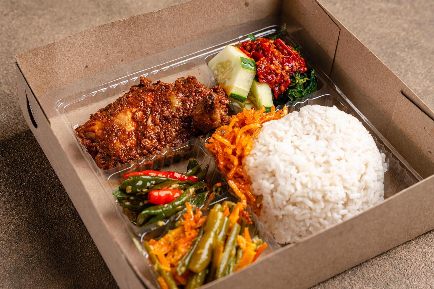 In Indonesian it is called Rice Box or Nasi kotak with ayam rendang. Usually distributed during celebrations or catering packaging. photo