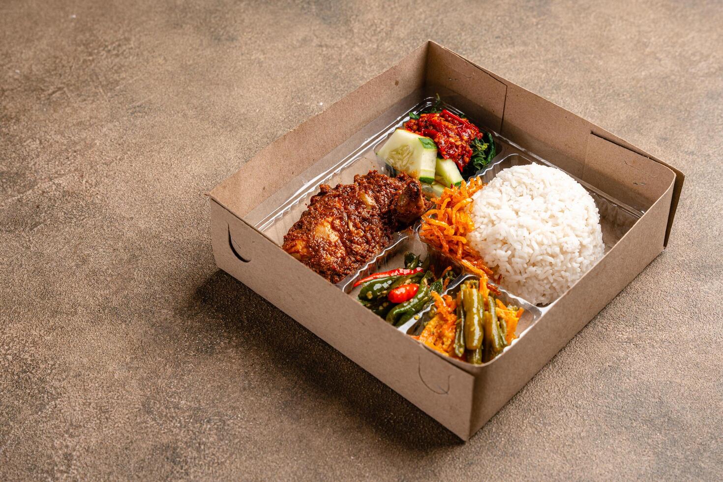 In Indonesian it is called Rice Box or Nasi kotak with ayam rendang. Usually distributed during celebrations or catering packaging. photo