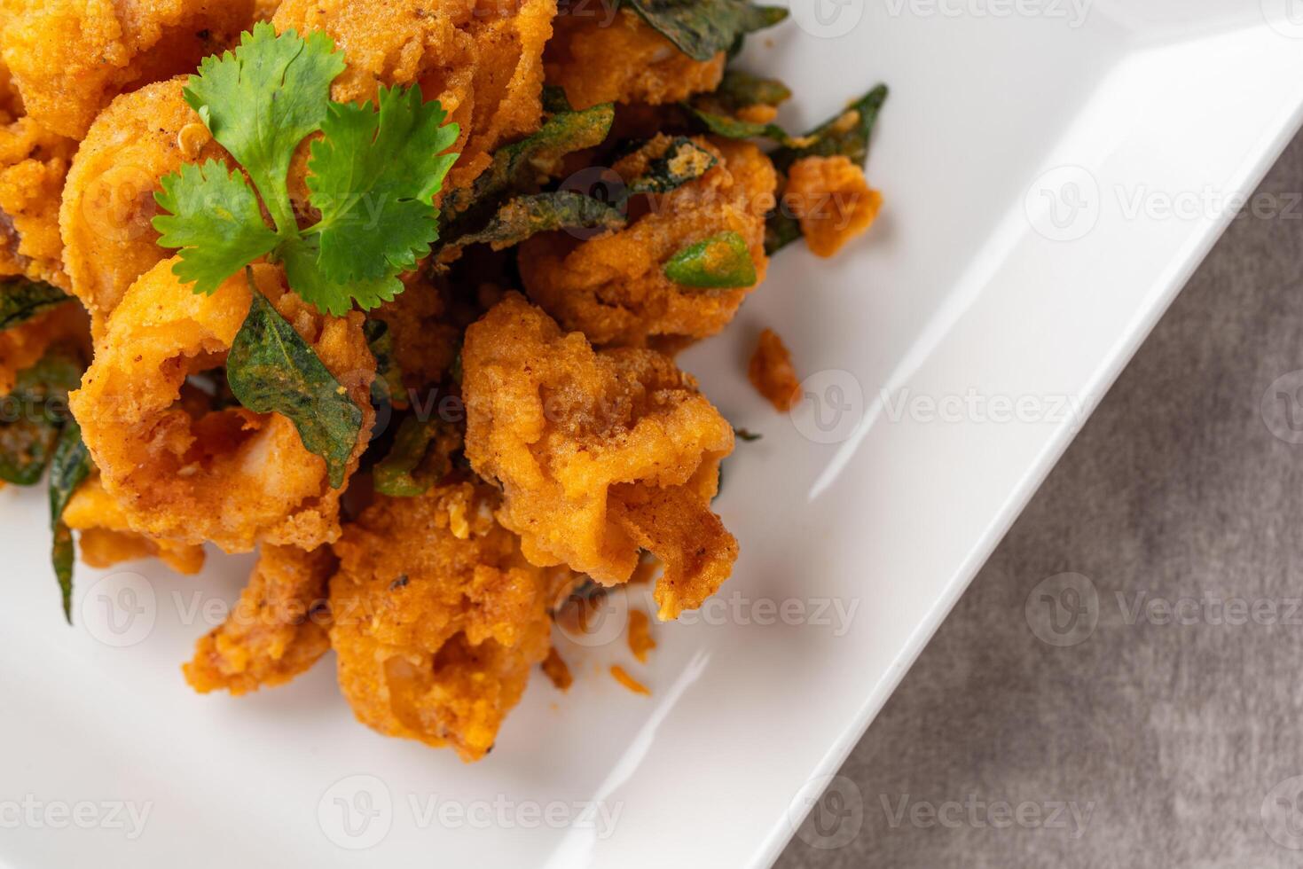 Stir Fried Squid with Salted Egg Yolk plating on white plate. photo
